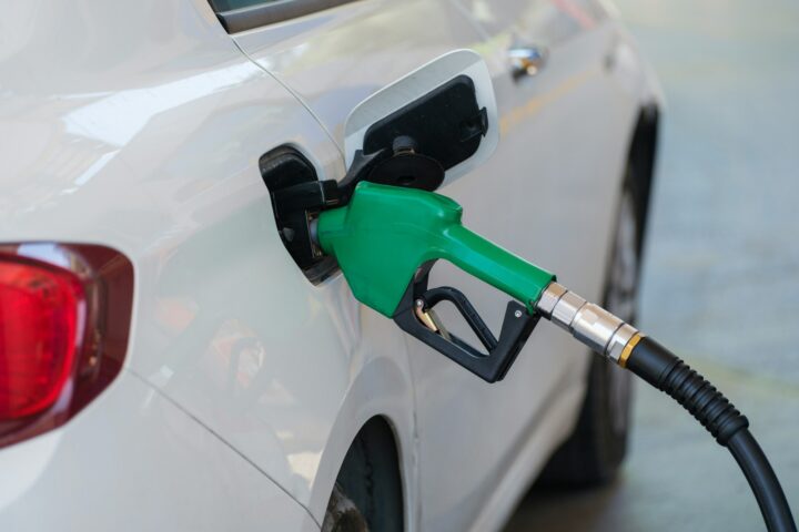 a white car with a green gas pump