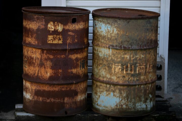 two rusty barrels sitting next to each other