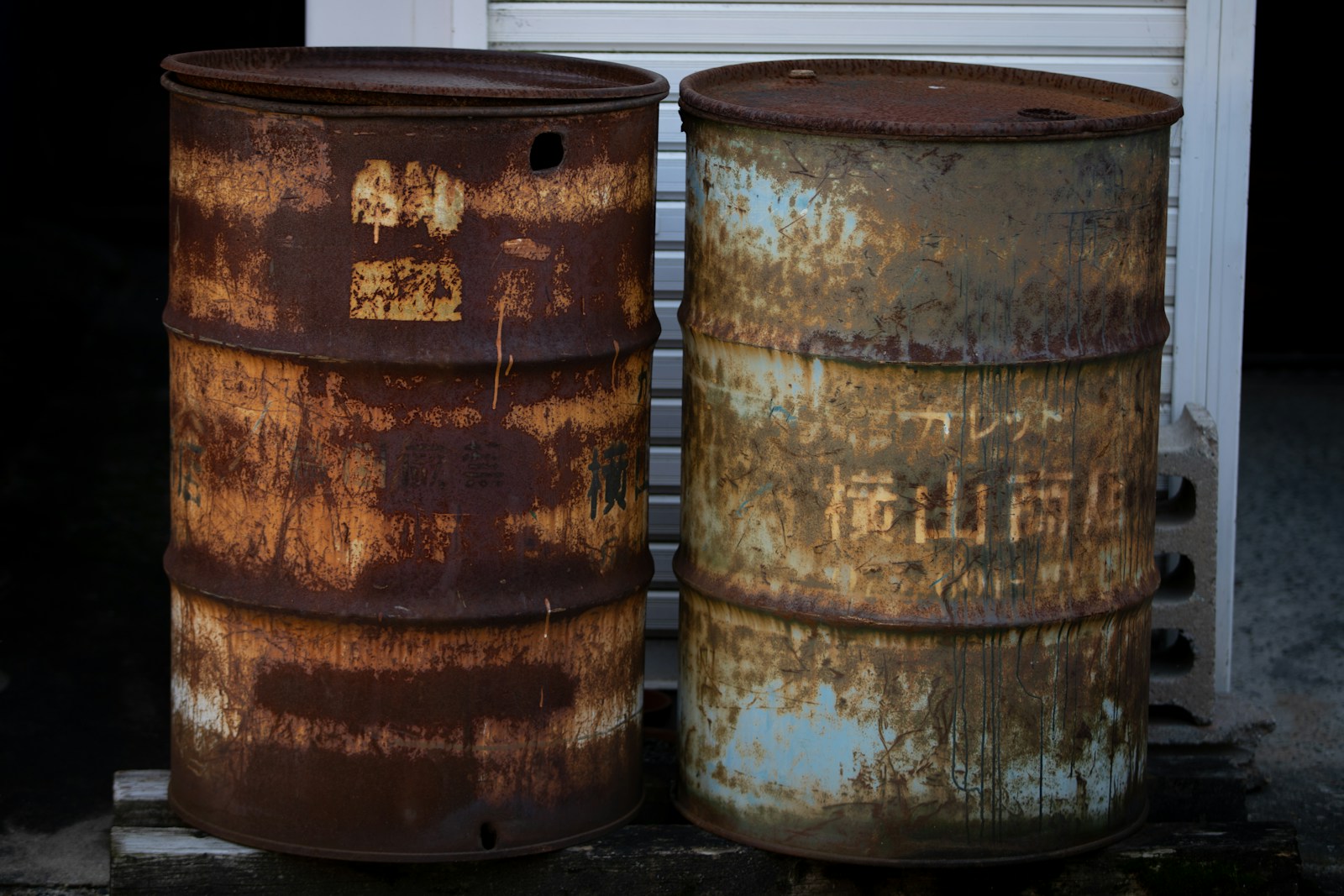two rusty barrels sitting next to each other